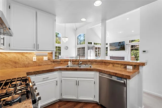 a kitchen with stainless steel appliances granite countertop a sink stove and cabinets