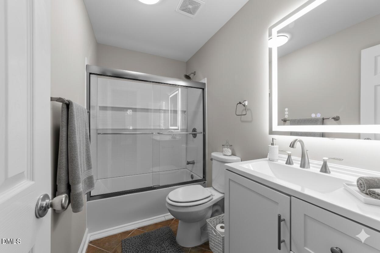 4110 Sedgewood Drive, Unit 302 Raleigh, NC 27612 - Photo 17 of 38 a bathroom with a toilet a sink and a mirror
