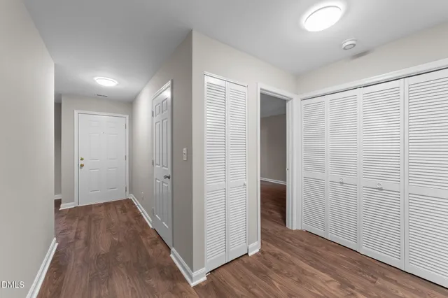 a view of an empty room with window and wooden floor