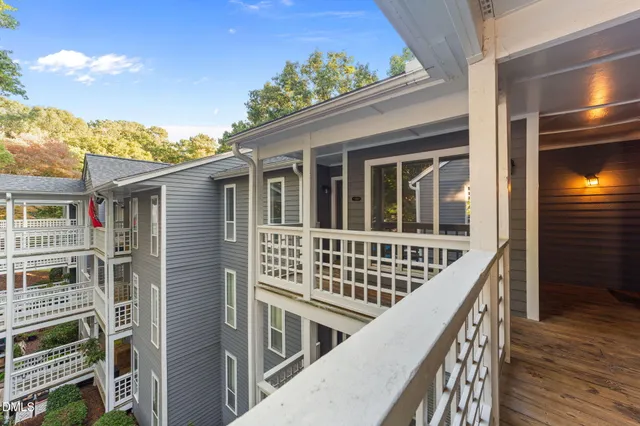 a view of a balcony with wooden floor and fence