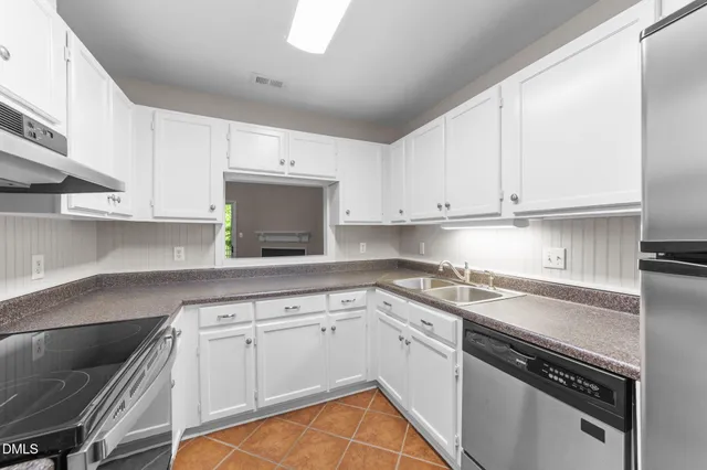 a kitchen with granite countertop a stove sink and cabinets