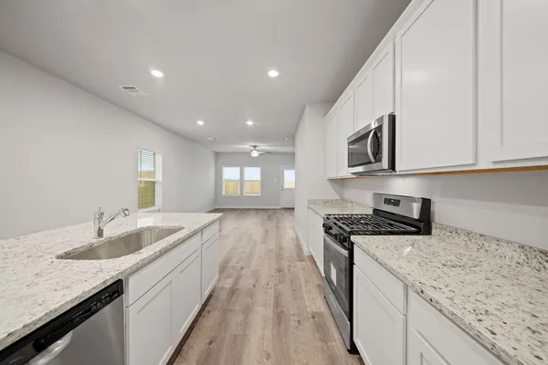 a kitchen with granite countertop sink stainless steel appliances and window