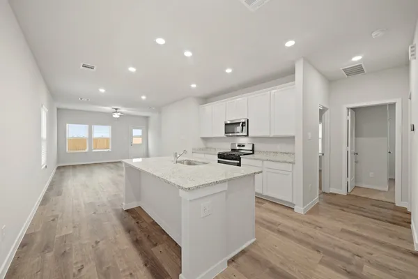 a kitchen with white cabinets and sink