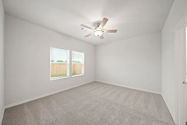 an empty room with a window and a ceiling fan