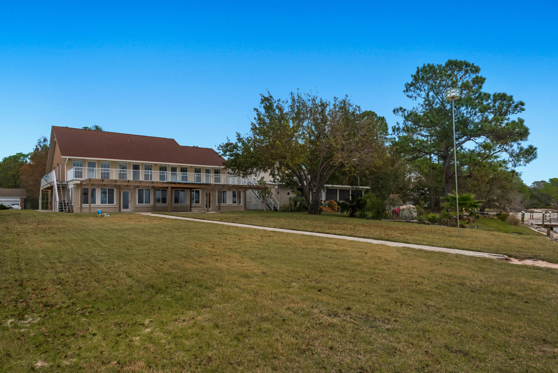 44 Dolphin Place Freeport, FL 32439 - Photo 75 of 76 a view of a house with a big yard and palm trees
