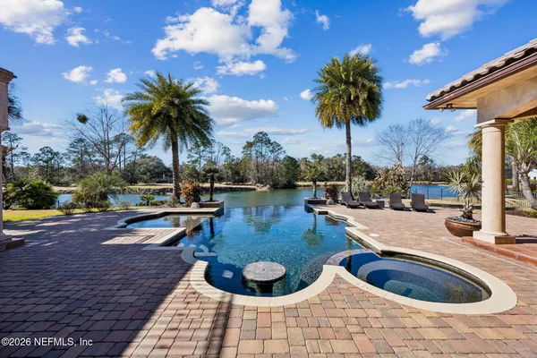 a view of a swimming pool with a patio and a yard