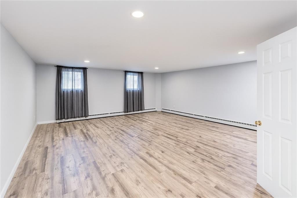 2650 East 26th Street, Unit 1A Brooklyn, NY 11235 - Photo 13 of 14 an empty room with wooden floor and windows