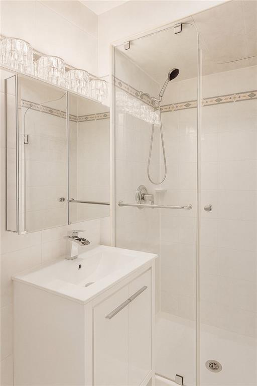 2650 East 26th Street, Unit 1A Brooklyn, NY 11235 - Photo 6 of 14 a bathroom with a shower sink and mirror