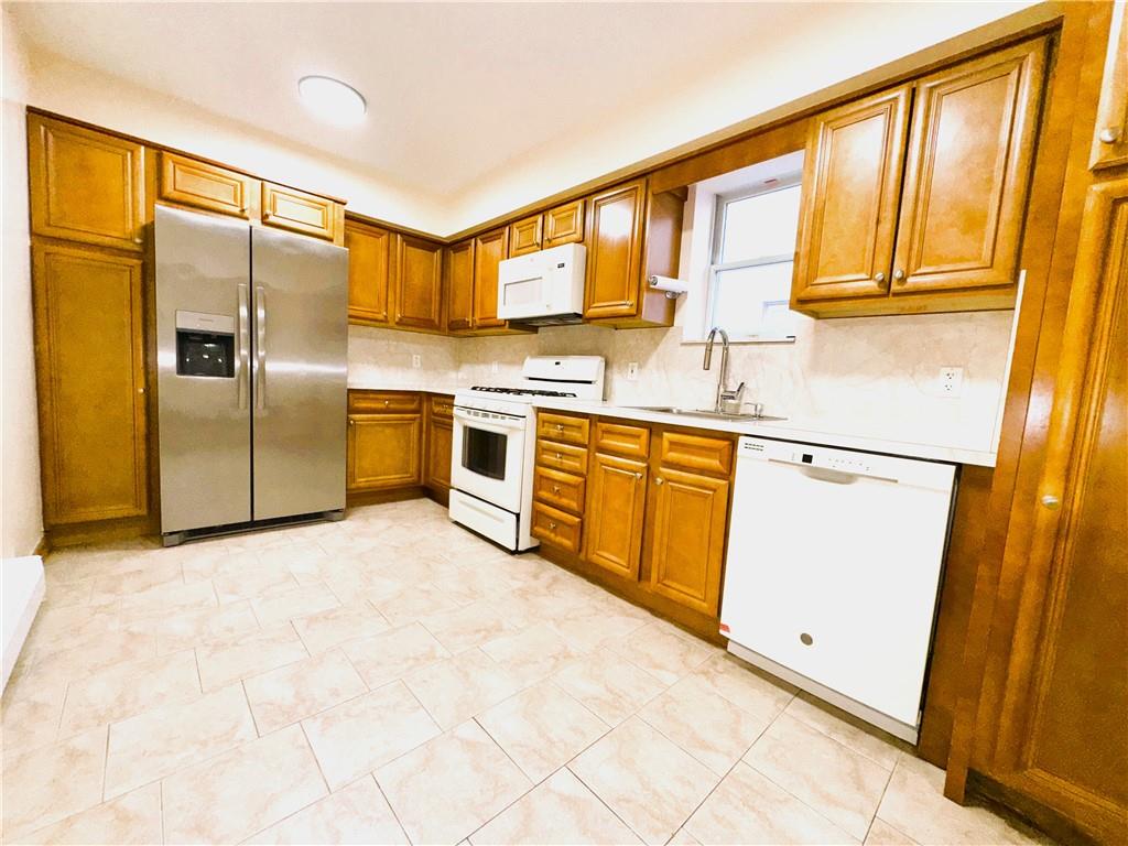 2650 East 26th Street, Unit 1A Brooklyn, NY 11235 - Photo 7 of 14 a kitchen with stainless steel appliances granite countertop a refrigerator sink and cabinets