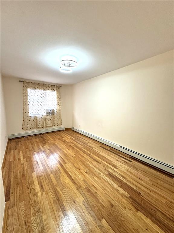 2650 East 26th Street, Unit 1A Brooklyn, NY 11235 - Photo 9 of 14 an empty room with wooden floor and windows
