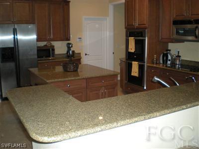 1629 Old Burnt Store Road North Cape Coral, FL 33993 - Photo 2 of 10 a kitchen with stainless steel appliances granite countertop a sink a stove and a refrigerator