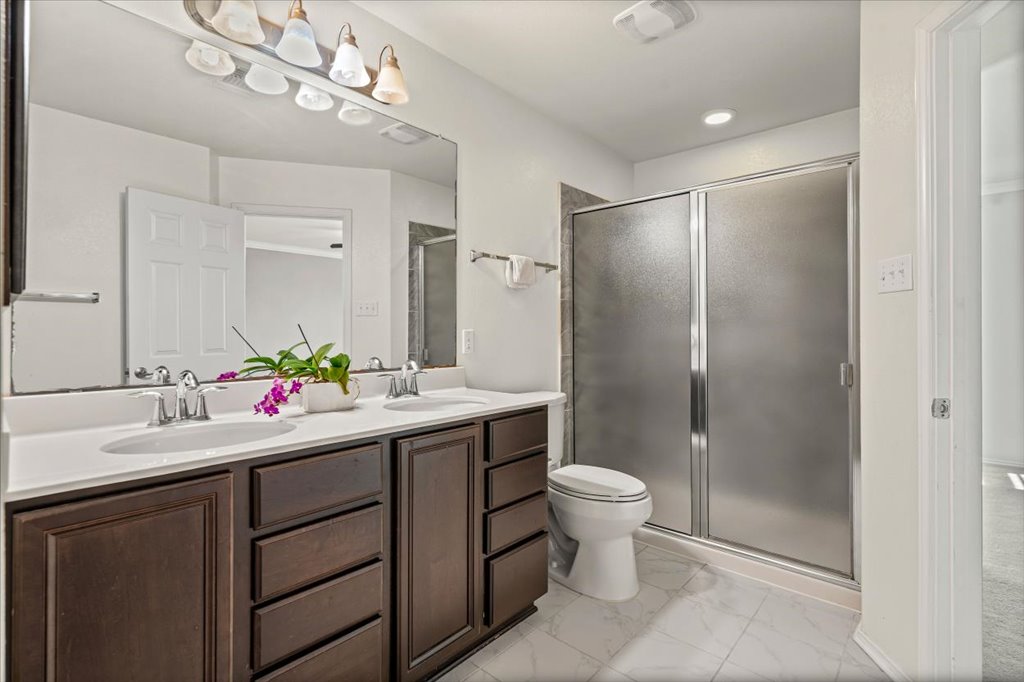 11229 Kirkland Hill Path Austin, TX 78754 - Photo 3 of 15 Full bathroom featuring double vanity, a shower stall, and light flooring