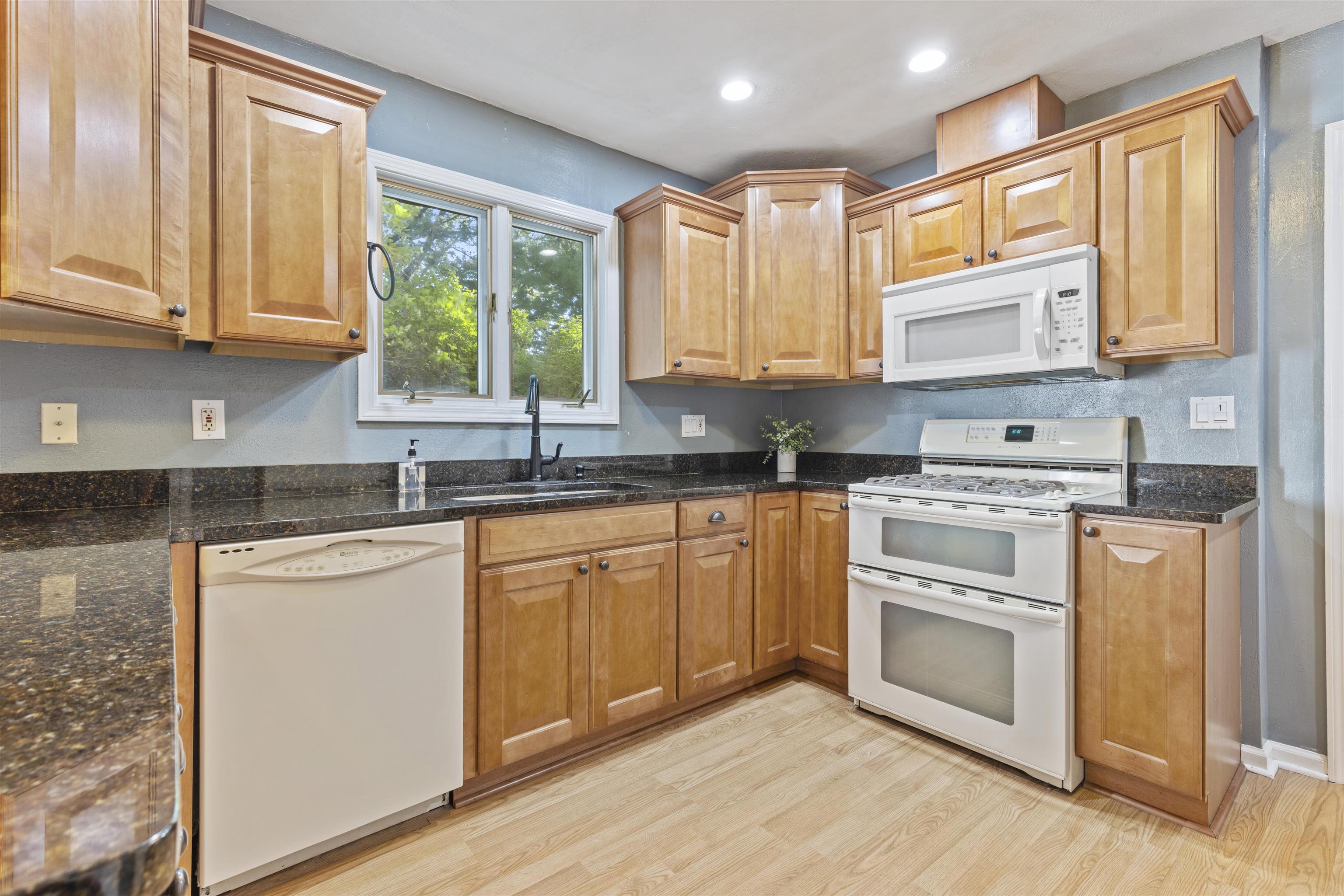 4976 Brigadoon Road Rockford, IL 61107 - Photo 8 of 32 a kitchen with stainless steel appliances granite countertop a stove a sink and white cabinets