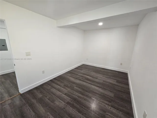 an empty room with wooden floor and entrance