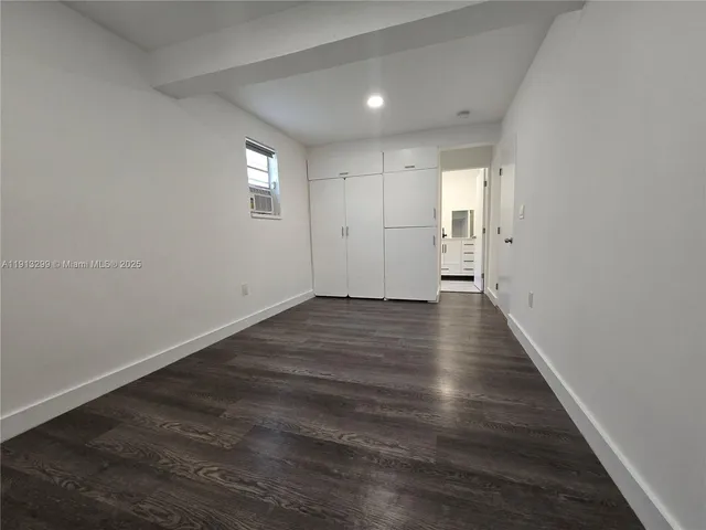 a view of empty room with wooden floor and window