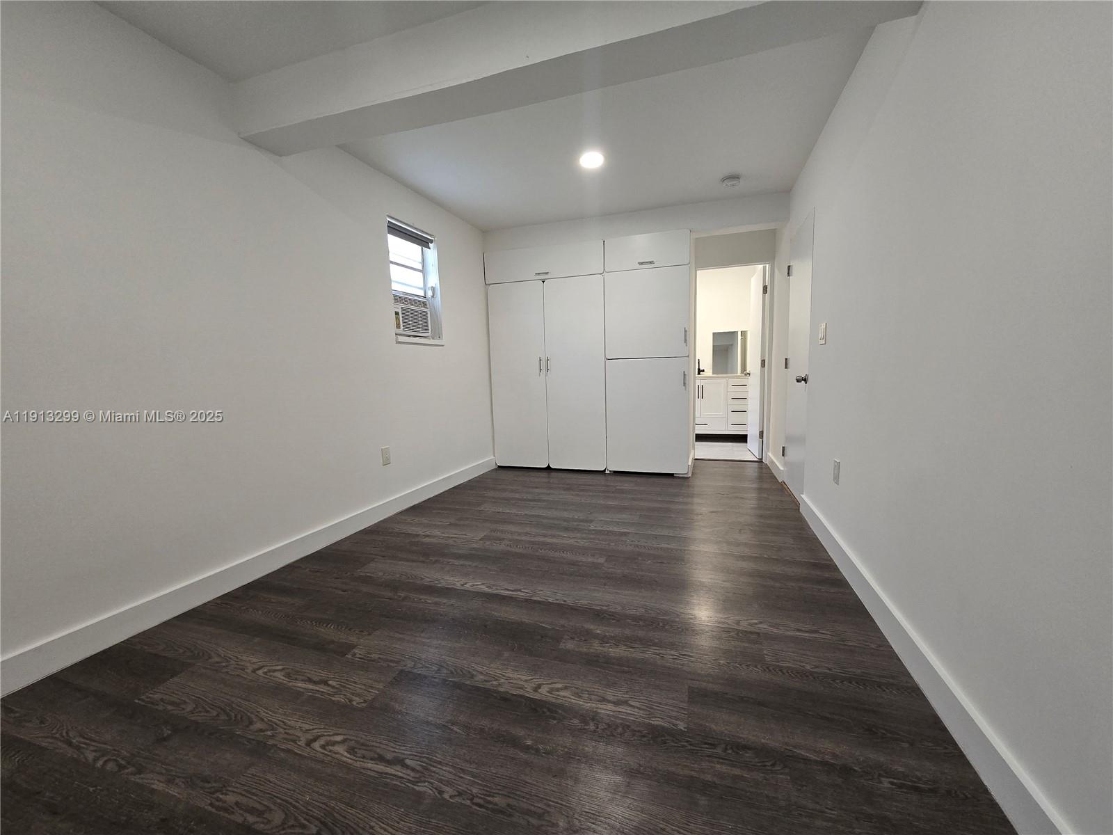 1629 Southwest 6th Street, Unit 13 Miami, FL 33135 - Photo 16 of 74 a view of an empty room with wooden floor and a window
