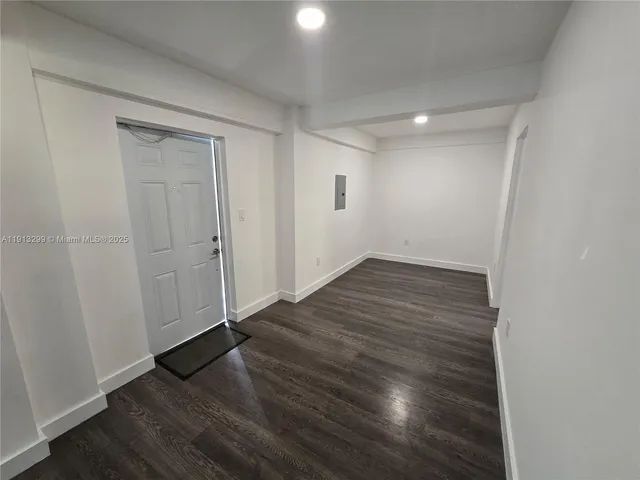 a view of empty room with wooden floor and window