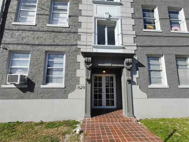 a front view of a residential apartment building with a yard