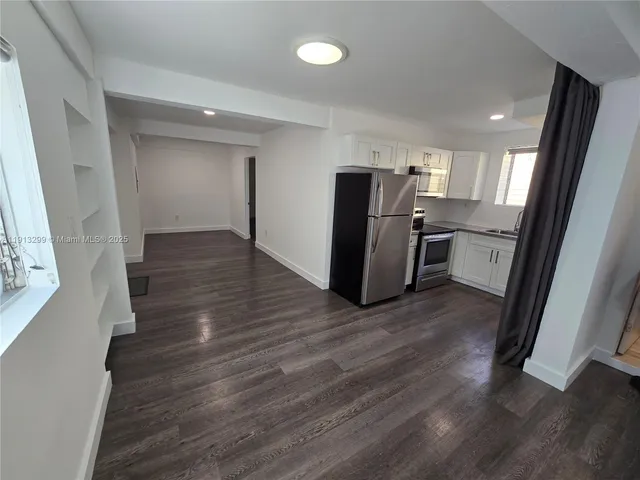 a view of a kitchen with a sink and a refrigerator