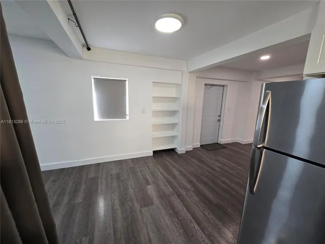 an empty room with wooden floor and entrance