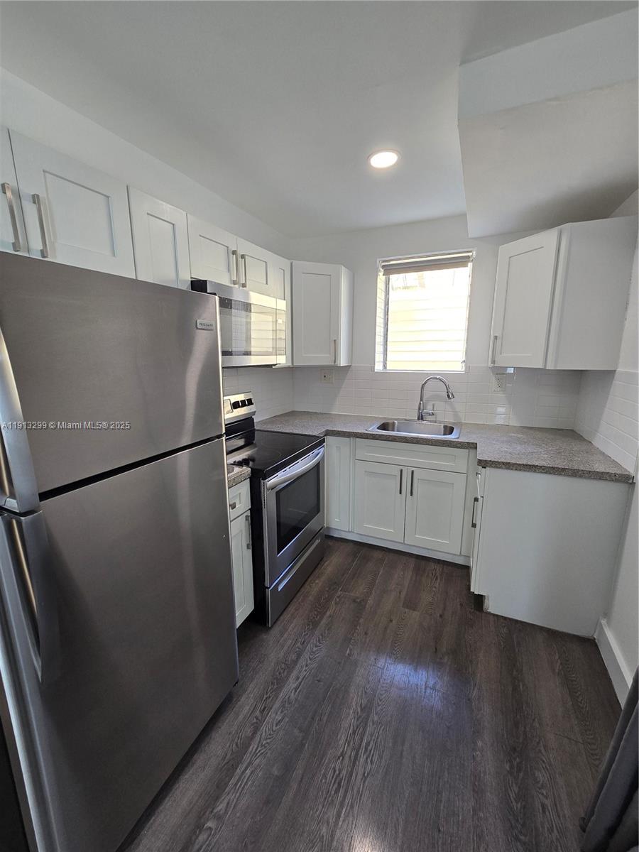 1629 Southwest 6th Street, Unit 13 Miami, FL 33135 - Photo 45 of 74 a kitchen with stainless steel appliances a refrigerator sink and wooden floor