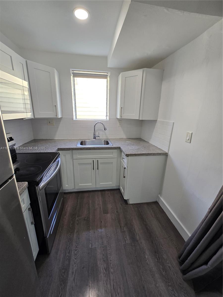 1629 Southwest 6th Street, Unit 13 Miami, FL 33135 - Photo 47 of 74 a kitchen with sink cabinets and wooden floor