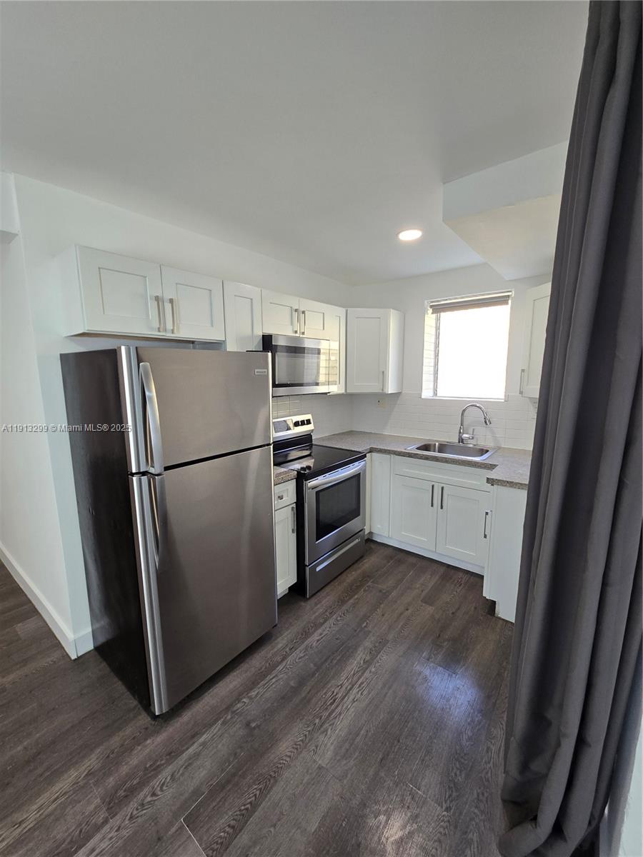 1629 Southwest 6th Street, Unit 13 Miami, FL 33135 - Photo 48 of 74 a kitchen with a refrigerator a sink a stove a microwave and cabinets