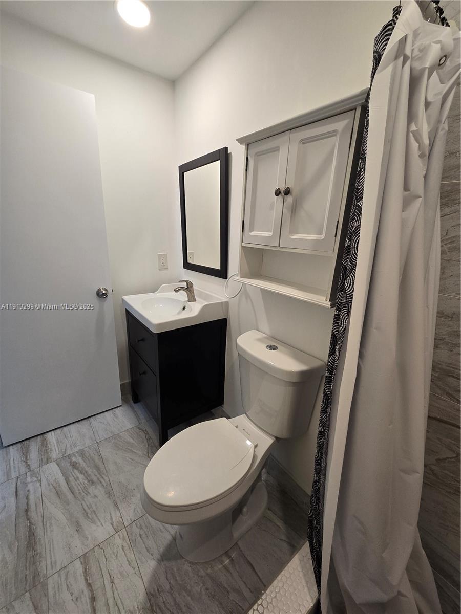 1629 Southwest 6th Street, Unit 13 Miami, FL 33135 - Photo 66 of 74 a bathroom with a toilet a sink and mirror