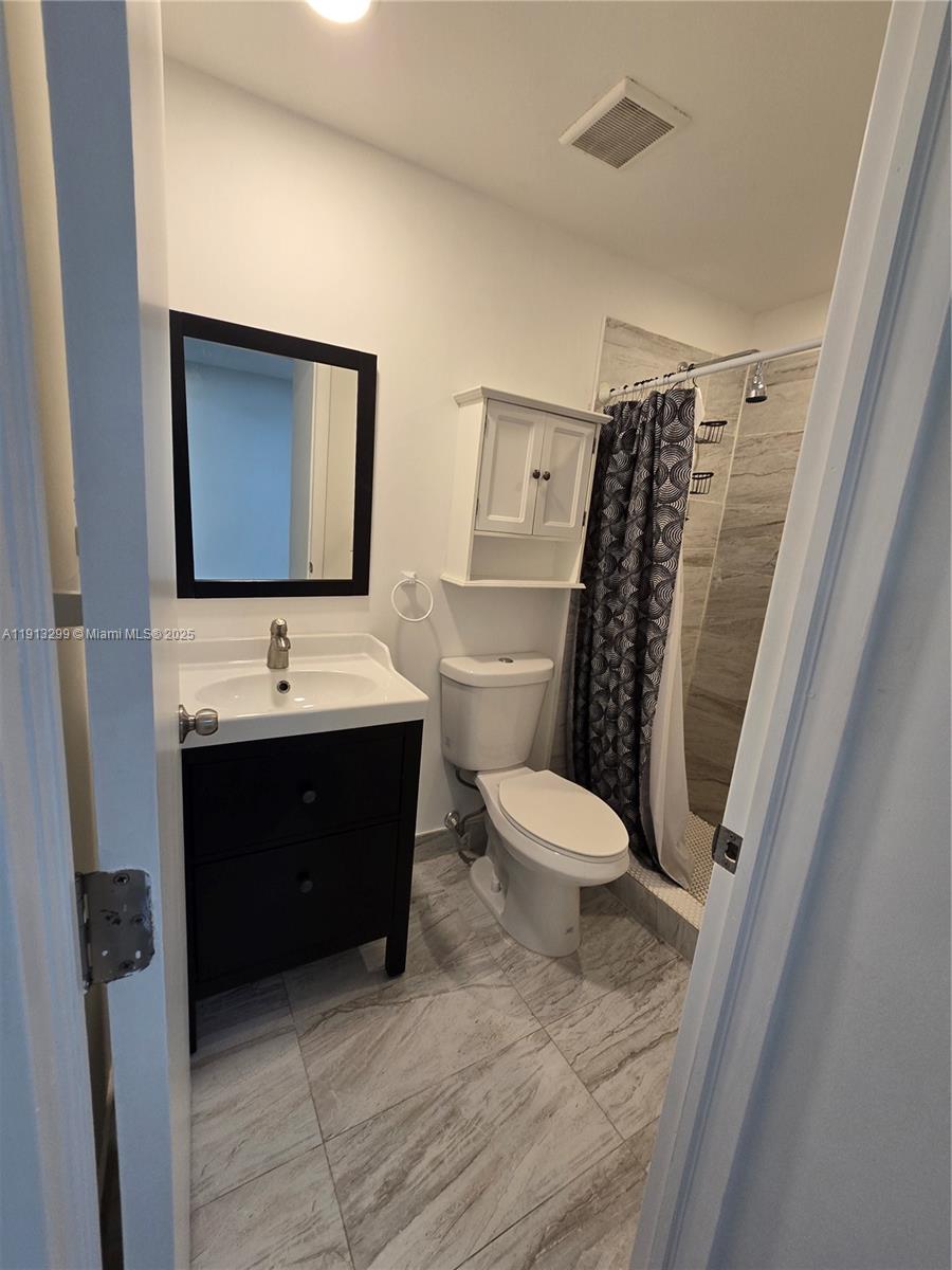 1629 Southwest 6th Street, Unit 13 Miami, FL 33135 - Photo 68 of 74 a bathroom with a toilet sink and mirror