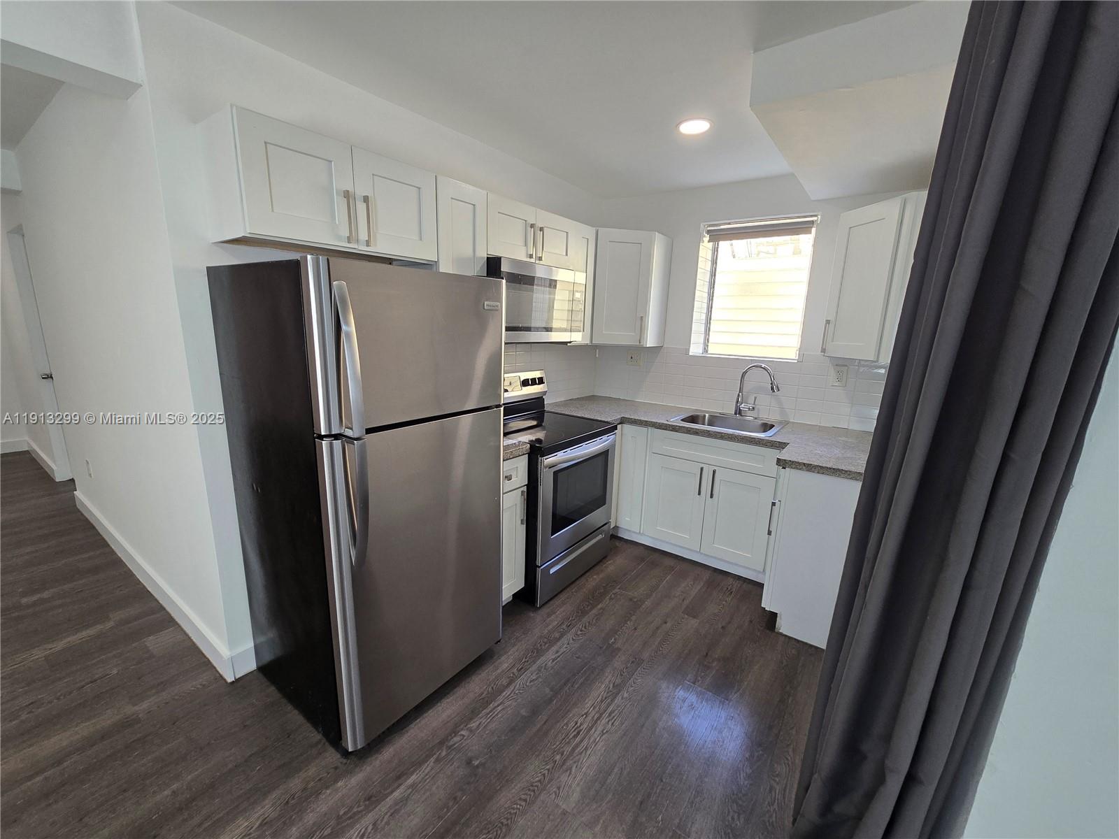 1629 Southwest 6th Street, Unit 13 Miami, FL 33135 - Photo 9 of 74 a kitchen with a refrigerator a sink a stove a microwave and cabinets