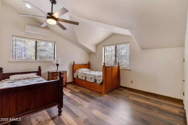 a workspace room with wooden floor table and windows