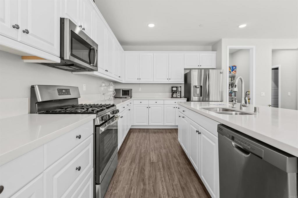 29809 Gypsy Vanner Way Menifee, CA 92584 - Photo 20 of 45 a kitchen with cabinets stainless steel appliances a sink and a stove
