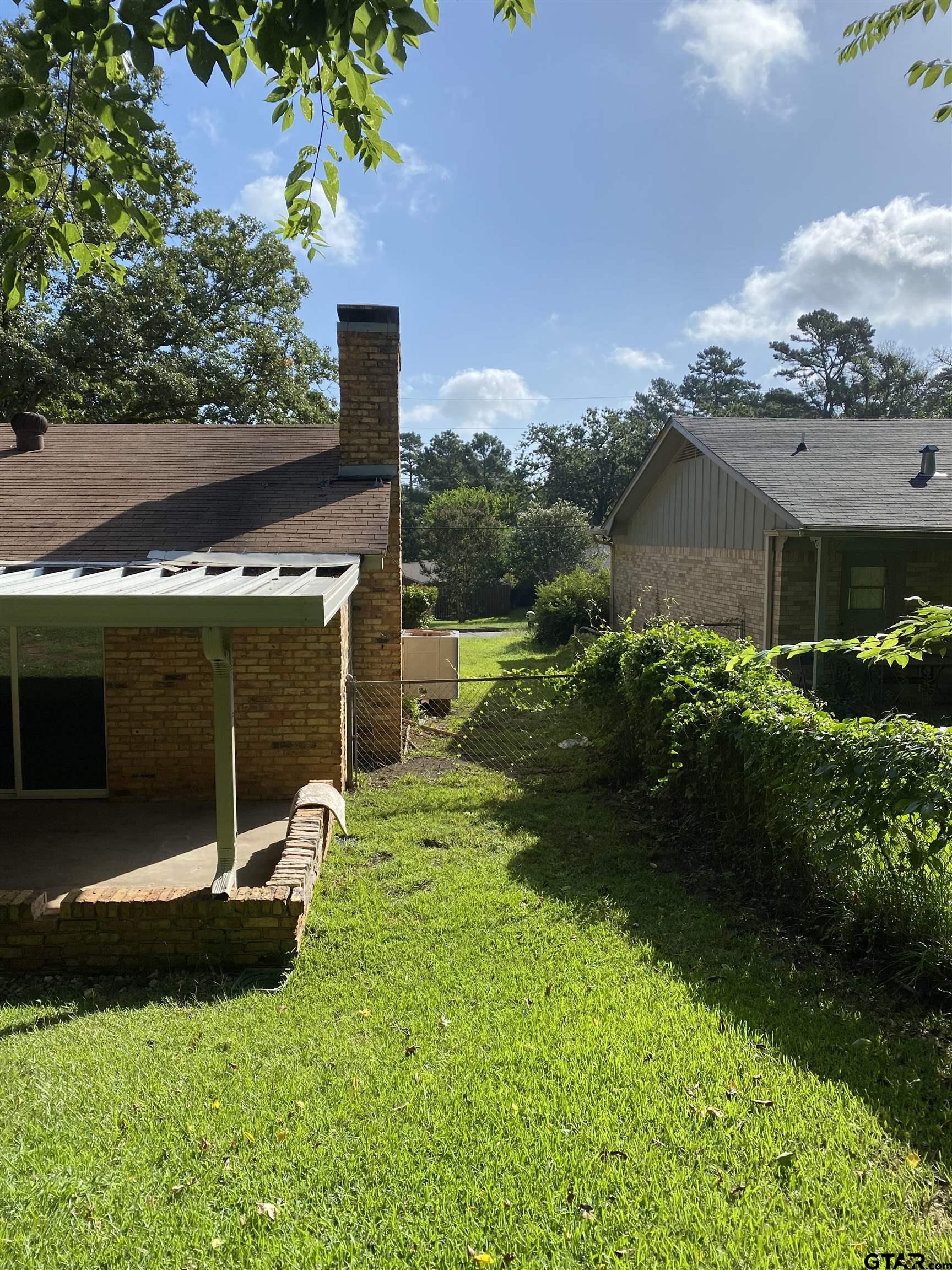 2613 Chelsea Drive Tyler, TX 75701 - Photo 19 of 33 a view of a chair and table with potted plants in front of house