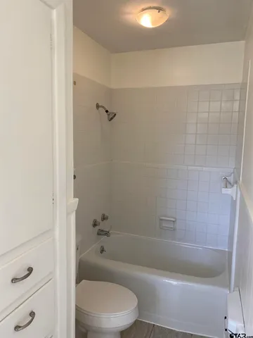 a white toilet sitting next to a shower