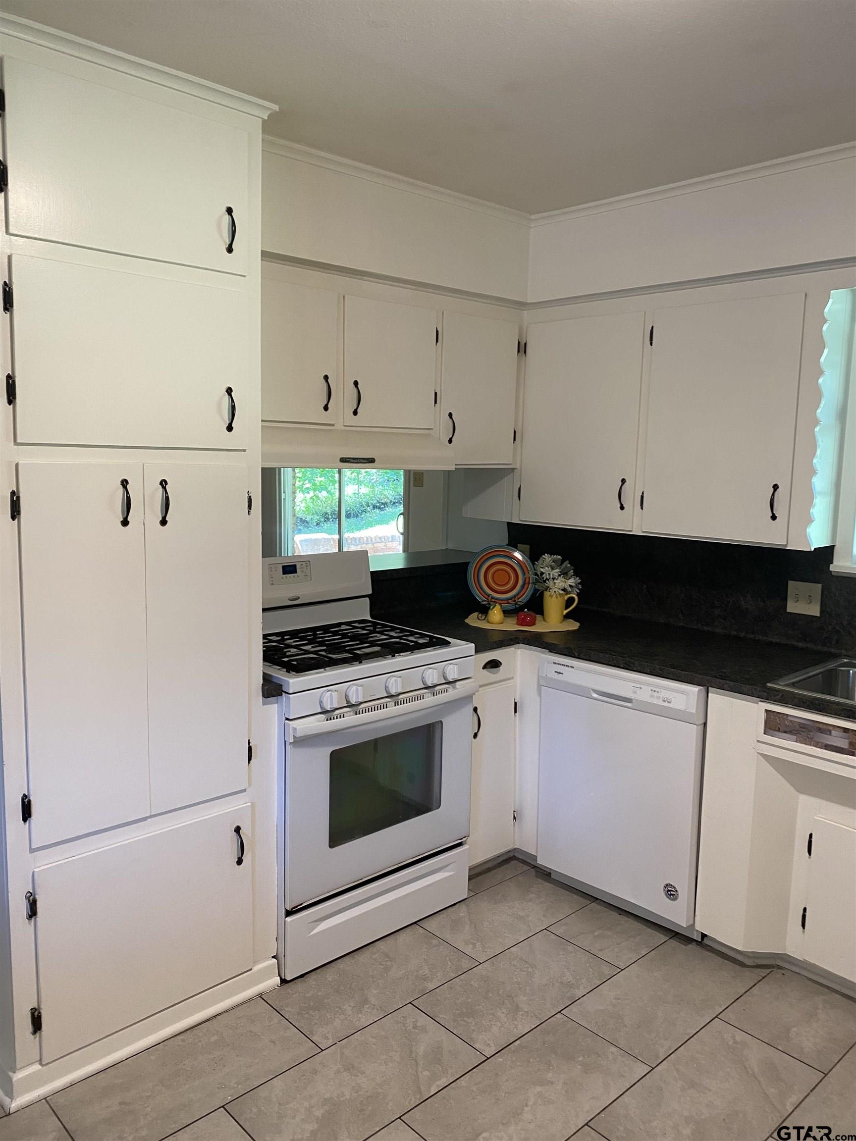 2613 Chelsea Drive Tyler, TX 75701 - Photo 31 of 33 a kitchen with white cabinets and white appliances