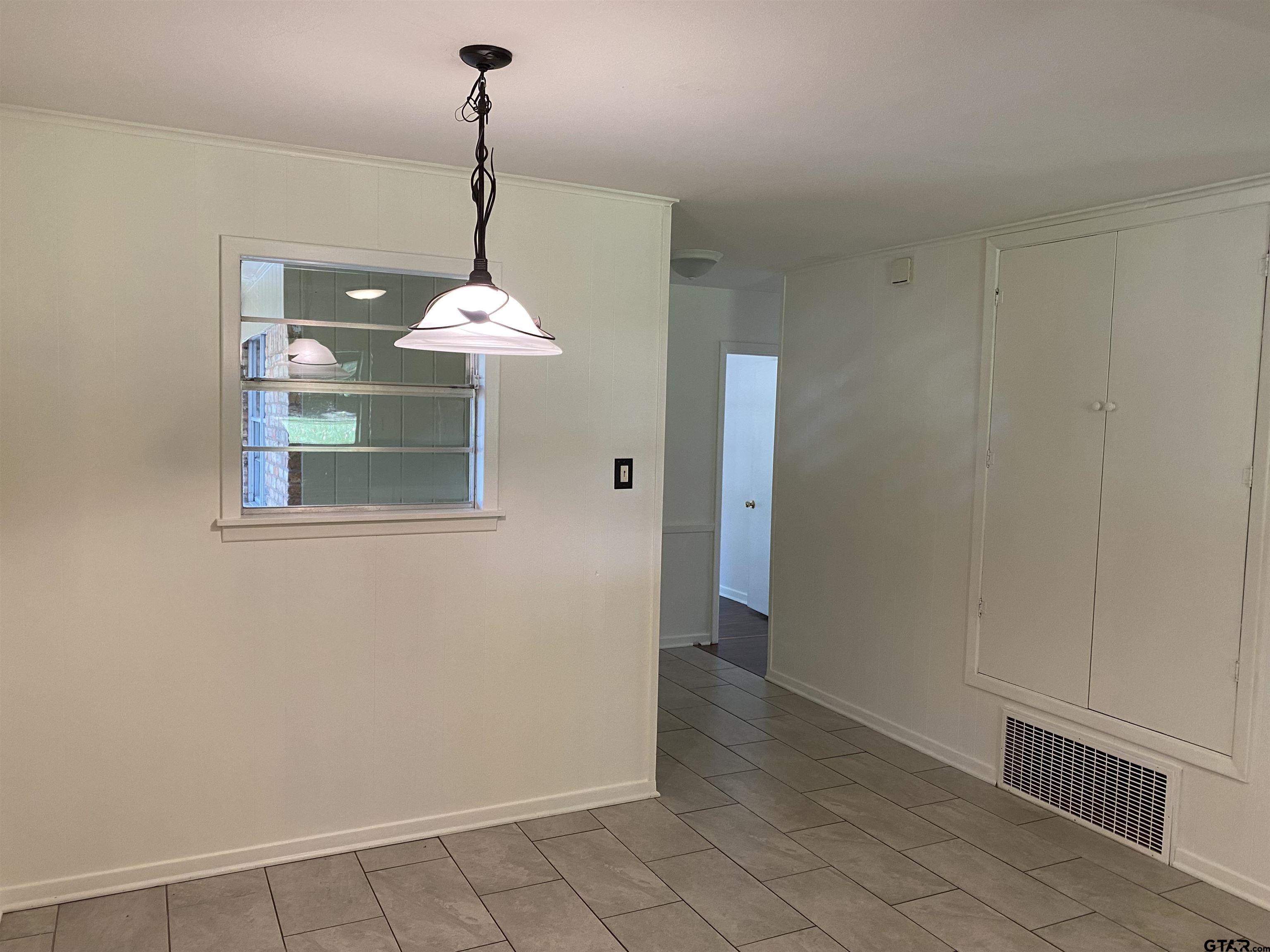 2613 Chelsea Drive Tyler, TX 75701 - Photo 33 of 33 a dining room with a window and chandelier