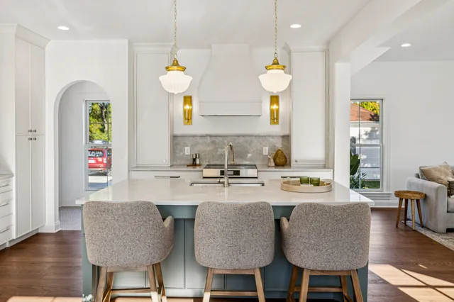 a kitchen with stainless steel appliances granite countertop a kitchen island a stove a table and chairs in it