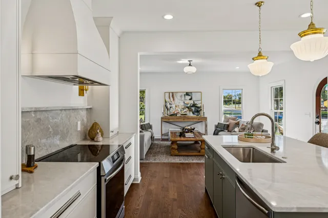 a kitchen with stainless steel appliances granite countertop a sink a stove top oven a counter space and cabinets