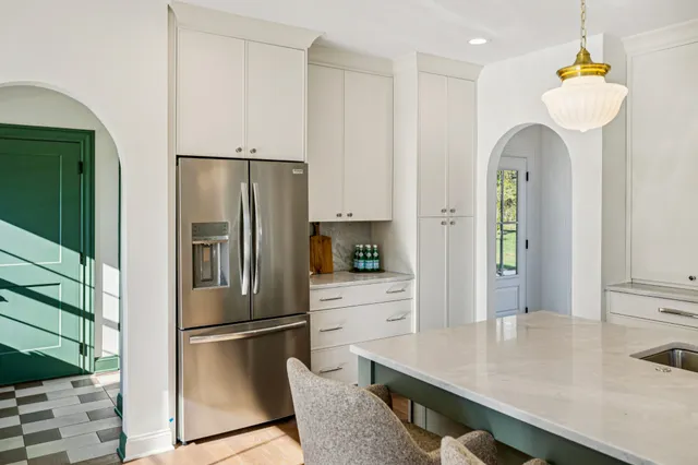 a kitchen with stainless steel appliances a refrigerator a sink and cabinets