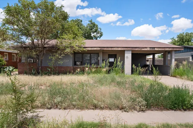 a view of a house with potted plants and a yard