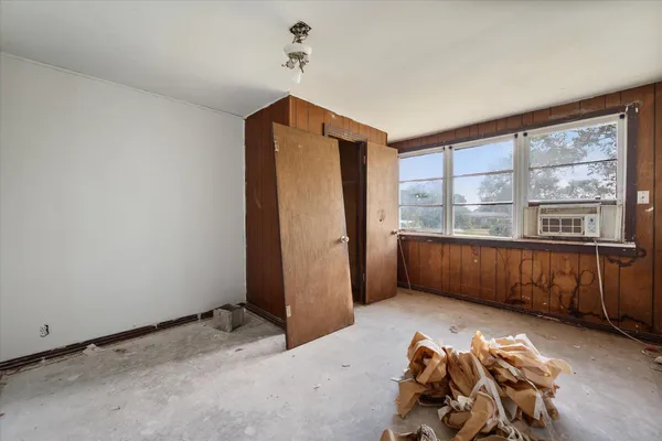 a view of a bedroom with a bed and a window