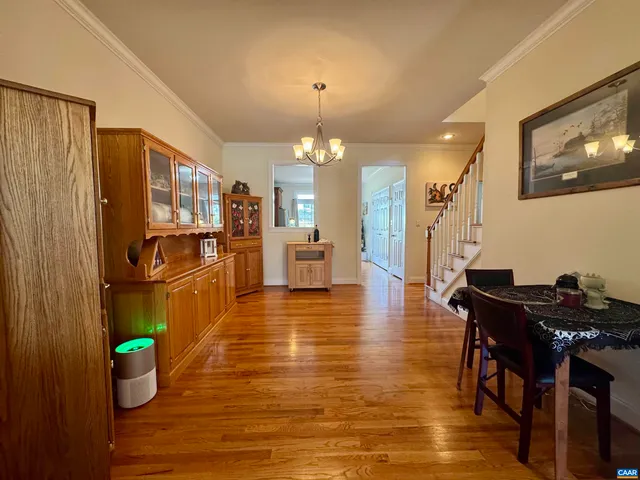 a living room with stainless steel appliances granite countertop furniture wooden floor and a window