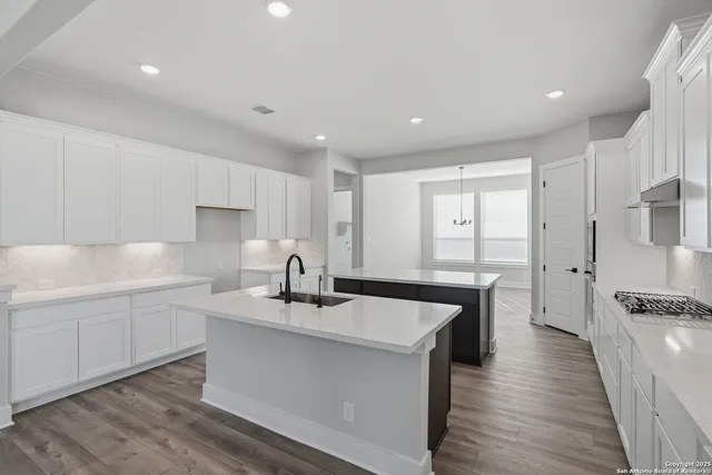 a kitchen with granite countertop a sink stove and cabinets