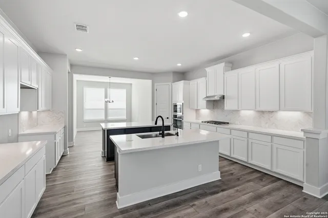 a kitchen with stainless steel appliances a sink stove and refrigerator