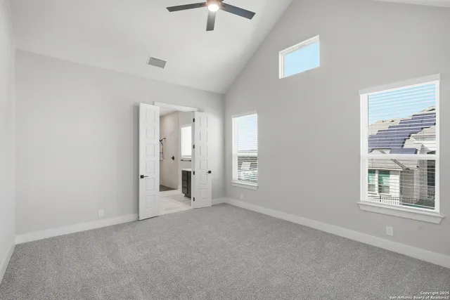 an empty room with ceiling fan and window