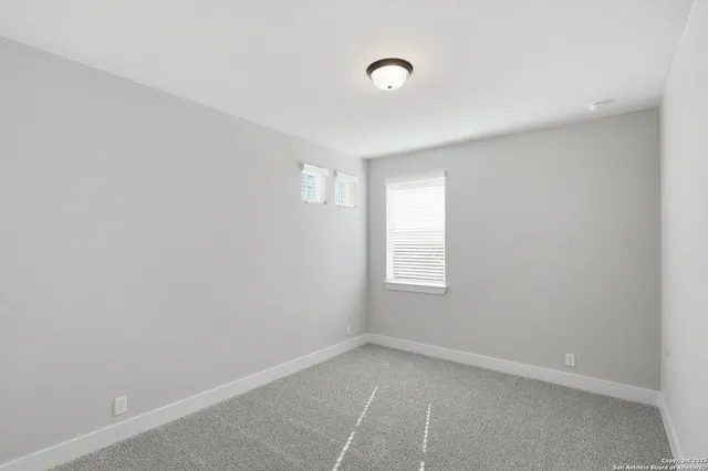 a view of a hallway with wooden floor and windows