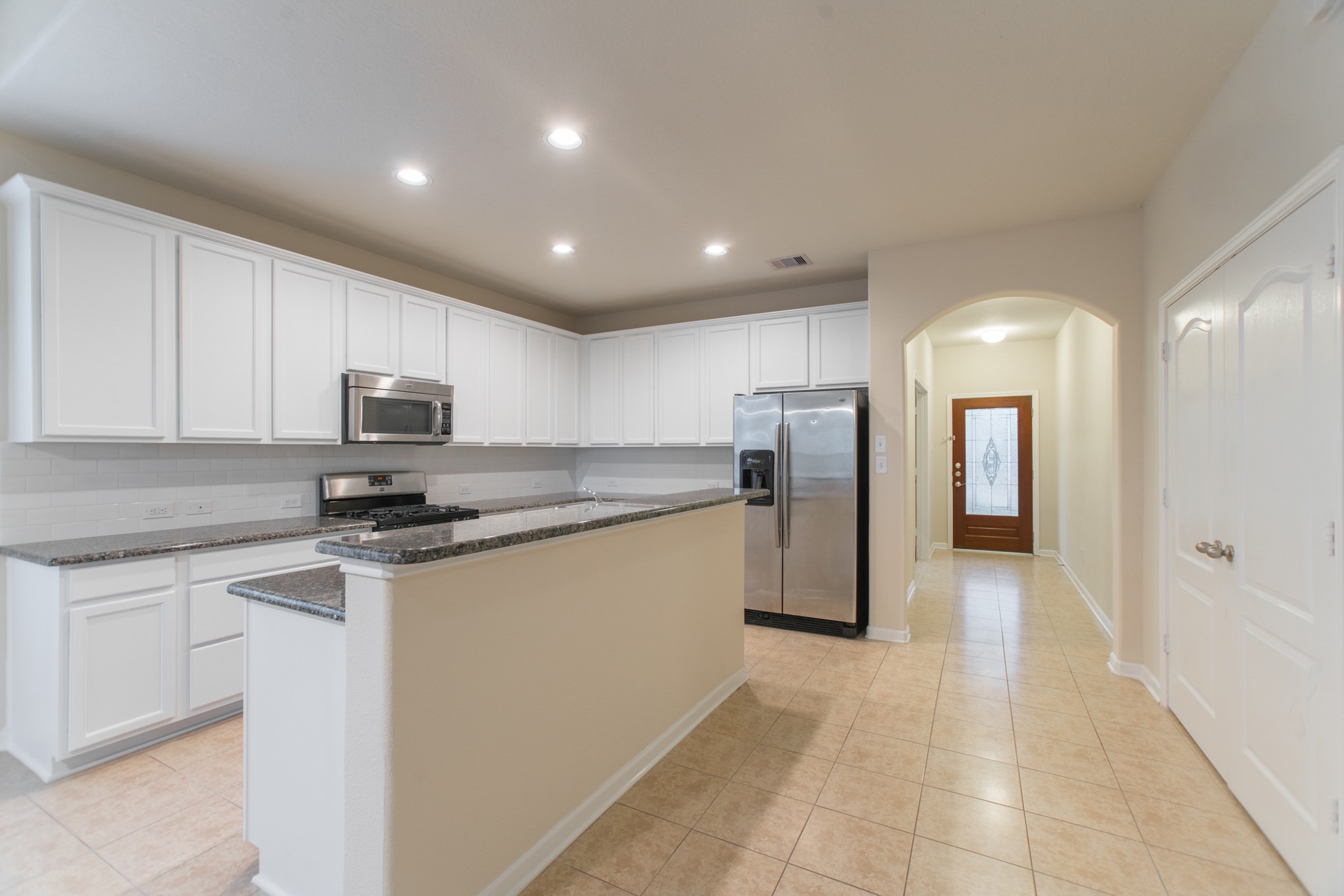 78 East Heritage Mill Circle The Woodlands, TX 77375 - Photo 15 of 50 a kitchen with stainless steel appliances granite countertop a refrigerator and a stove