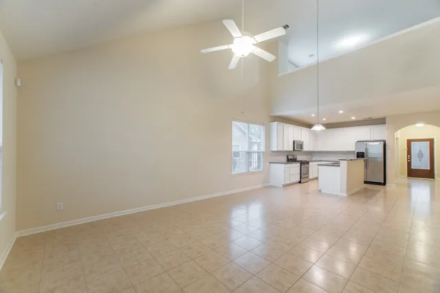 a view of a livingroom with a ceiling fan and kitchen space