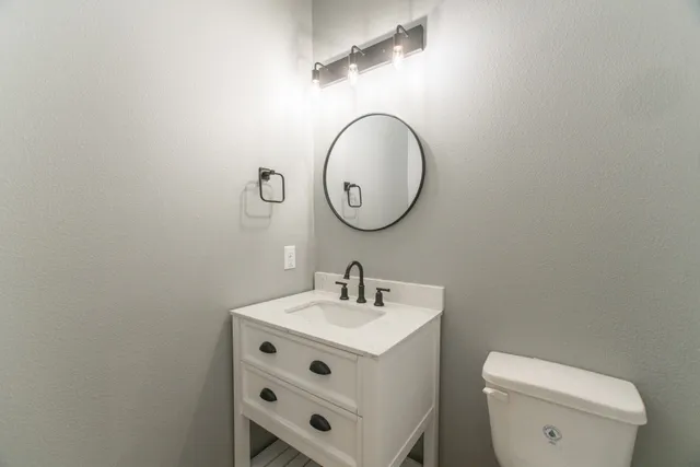 a bathroom with a toilet a sink and a mirror