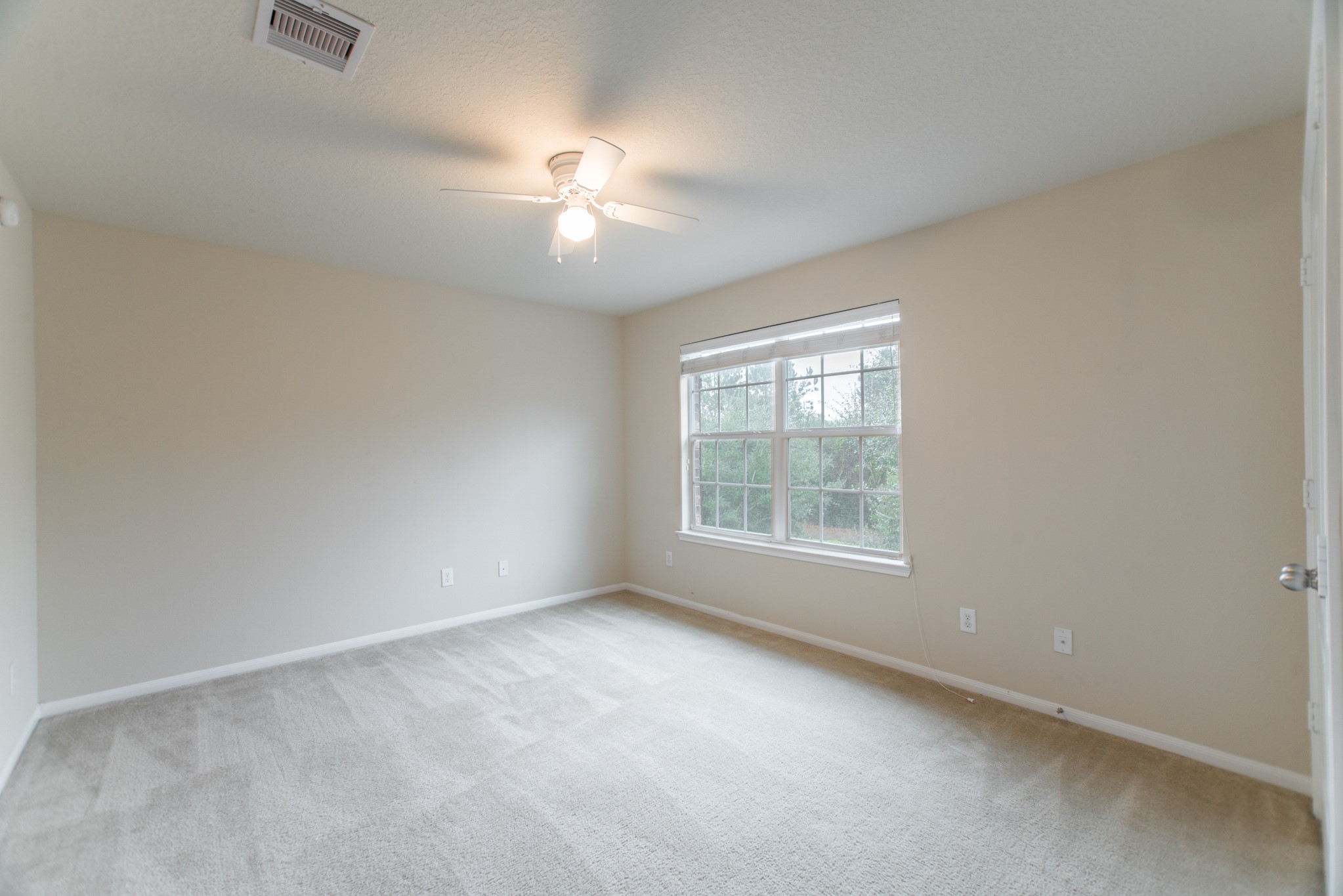 78 East Heritage Mill Circle The Woodlands, TX 77375 - Photo 37 of 50 an empty room with chandelier fan and windows